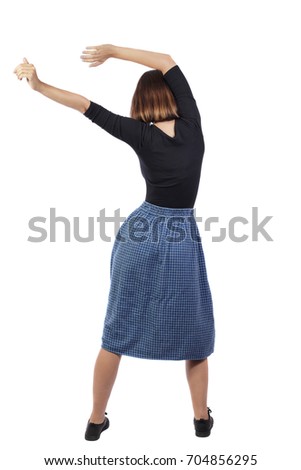 back view of dancing young beautiful  woman in dress. girl  watching. Rear view people collection. Isolated over white background. A girl in a blue checkered skirt is holding her skirt with her hand.