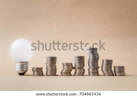 Budget idea concept, heap of coins with small light bulb