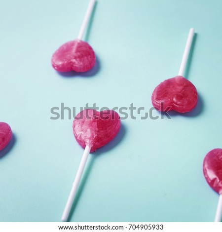 Valentine's day heart shape lollipop candy on sky blue paper background