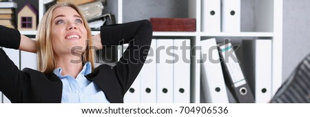 Business woman resting in the office after a working day throwing her feet on the table leaning back her hands behind her head