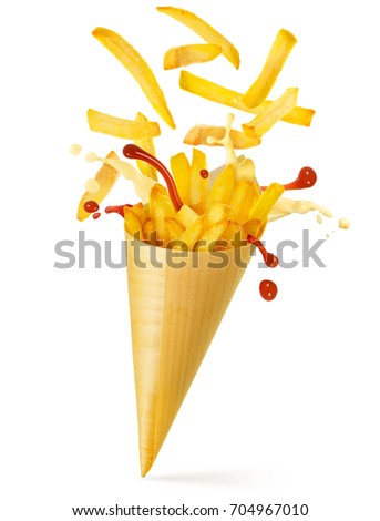 french fries, mayo and ketchup spilling out of a paper cone  Royalty-Free Stock Photo #704967010