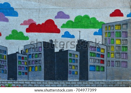 The old wall, painted in color graffiti drawing with aerosol paints. An image of a multitude of skyscrapers with multi-colored windows