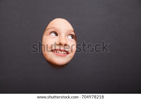 Pretty small girl with cartoon plaits against the black background. Photo face stand-in cutout