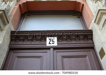 Number 25 sign, twenty-five posted over an entrance door of a building.