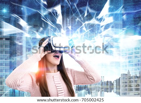 Close up portrait of a young woman wearing a pink cardigan and VR glasses. She is amazed by what she is seeing. She is standing against a night city background. Polygons. Toned image double exposure