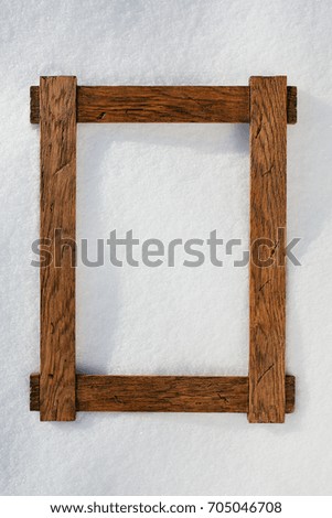wooden frame on natural snow, copy-space background