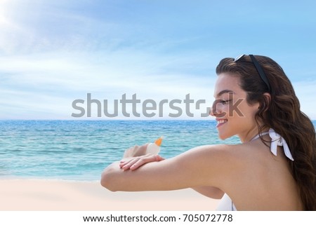 Digital composite of Happy woman at the beach putting on cream