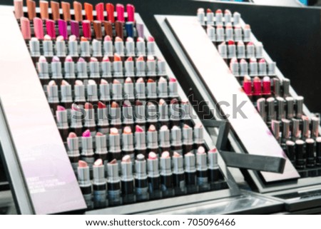 blurry background of Various shades of lipstick, a trial size displayed in shops selling cosmetics.