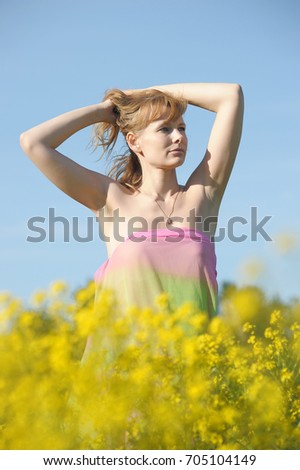 Woman in purple dress in a field with rape