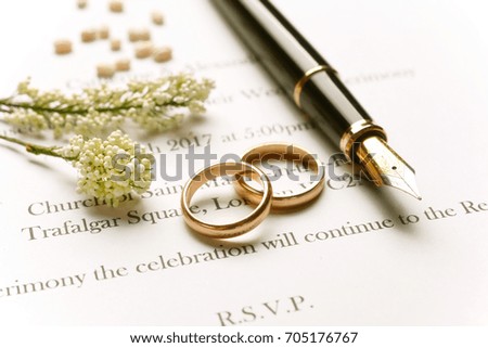 Wedding invitation with gold rings - closeup