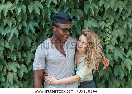 Portrait of loving couple embracing in front an ivy wall