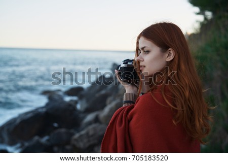 Camera, woman in a plaid takes pictures of the sea, evening                               