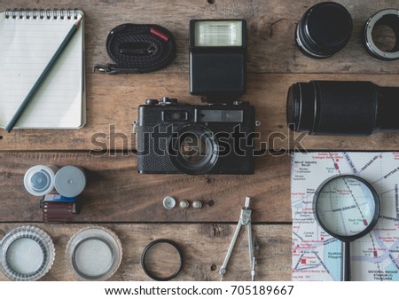 top view of work space photographer, Travel accessories with retro camera, map, lens, film, lens filter and camera accessories on wooden background, travel concept.