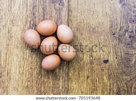 Half a dozen brown eggs on a wooden background