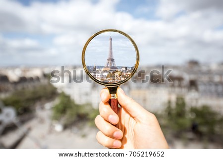 Looking on the Eiffel tower through the magnifying glass in Paris