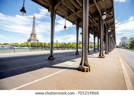 Cityscape view on the old iron bridge with Eiffel tower on the background during the sunny day in Paris