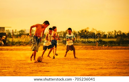 An action picture of a group of kids playing soccer football for exercise.