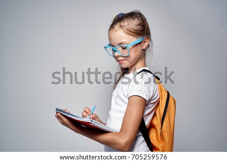 little girl in blue glasses with a backpack.