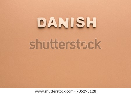 Word Danish on beige background. Foreign language learning, education concept