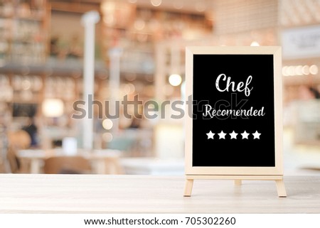 Chef recommend and five star on blackboard standing over blur restaurant background, copy space for text, food and drinks background, banner
