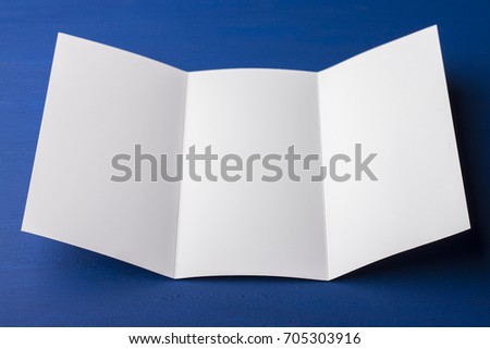 Blank tri fold brochure on blue background to replace your design or message. A mock-up for brand identification for designers  