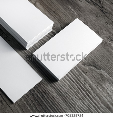 Photo of blank paper business cards on wooden background.