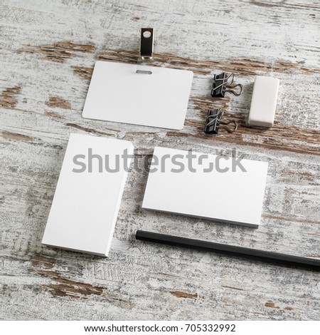 Photo of blank stationery on wood table background. ID template. Bank business cards, badge, pencil and eraser on vintage wood table background.