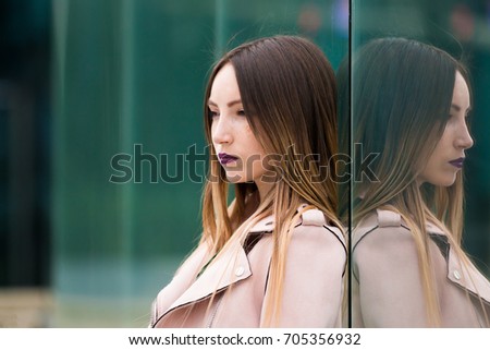 Portrait of beautiful informal fashionable girl on modern building background