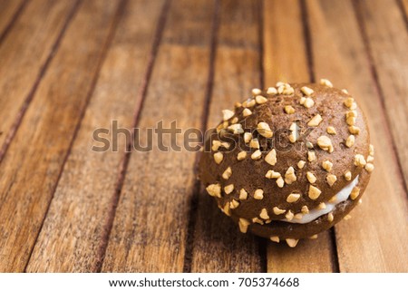 One chocolate cookie over brown wooden background with copy space