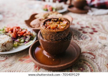 The national Turkish dish in the pot that is broken before use is called Testi-kebab. Restaurant with Turkish food. Royalty-Free Stock Photo #705409129
