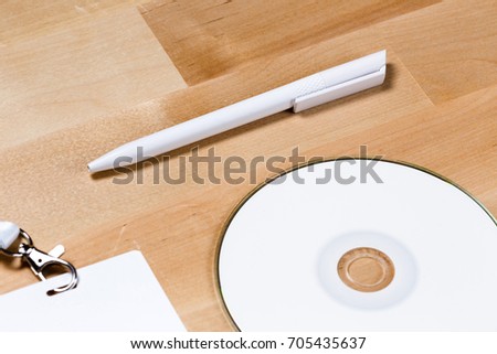mock up of blank notebook, cd disc and badge on wooden office desk
