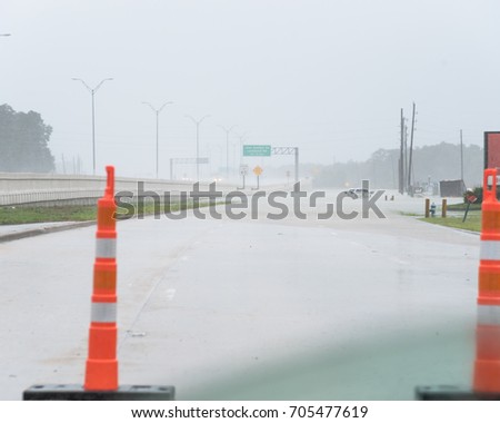 High water rising in frontage road North Sam Houston Parkway Northeast of Houston with traffic cone. Pickup truck swamped by flood Harvey Tropical Storm. Disaster Motor Vehicle Insurance Claim Themed