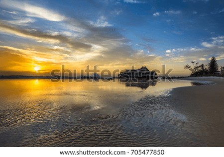 high tide big surf waves crashing Gold coast beach sunrise reflections sunburst 