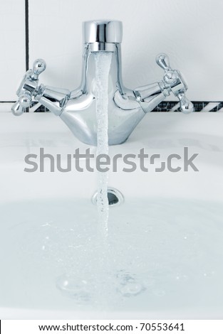 tap with a water stream. A bathroom with a white tile