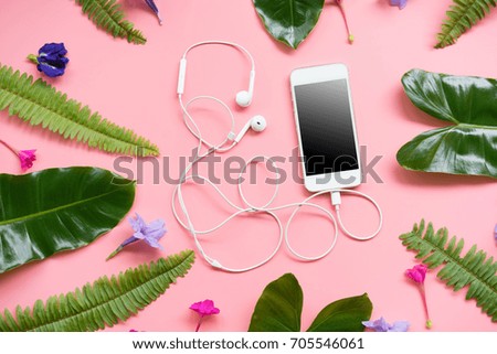 Flat lay design of Blank Smartphone  with leaf on pink pastel background.