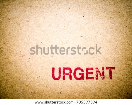 Red URGENT rubber stamp on carton texture background with copy space. Retro tone picture. 