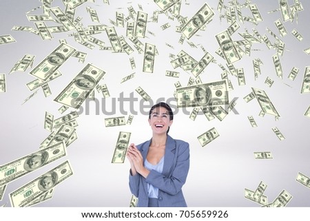 Digital composite of Happy business woman looking at money rain against white background