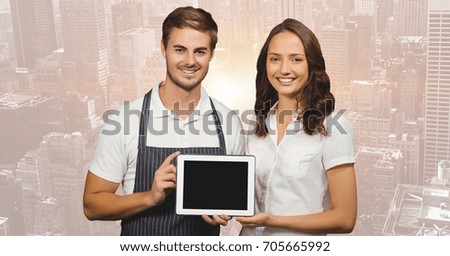 Digital composite of Shop owners with tablet against blurry skyline