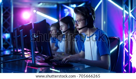 Team of Teenage Gamers Play in Multiplayer PC Video Game on a eSport Tournament. Captain Gives Commands into Microphone, Trying Strategically Win the Game. Royalty-Free Stock Photo #705666265