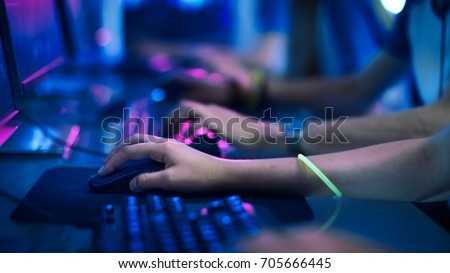 Close-up On Row of Gamer's Hands on a KeyBoard.jpgs, Actively Pushing Buttons, Playing MMO Games Online. Background is Lit with Neon Lights.
