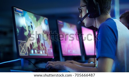 Team of Professional eSport Gamers Playing in Competitive  MMORPG/ Strategy Video Game on a Cyber Games Tournament. They Talk to Each other into Microphones. Arena Looks Cool with Neon Lights. Royalty-Free Stock Photo #705666487
