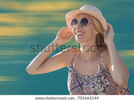 Digital composite of Woman with hat and sunglasses against blurry yellow and blue background