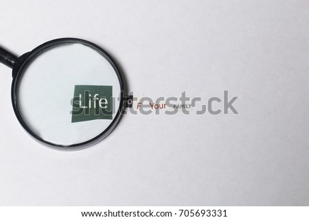 Criminal activity. Preparation of a letter with threats. Letters cut from different editions are pasted onto a white sheet of paper. Above the inscription lies a magnifying glass.