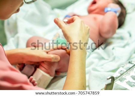 The image of a nurse hand is using a syringe gradually vaccinate baby's leg.