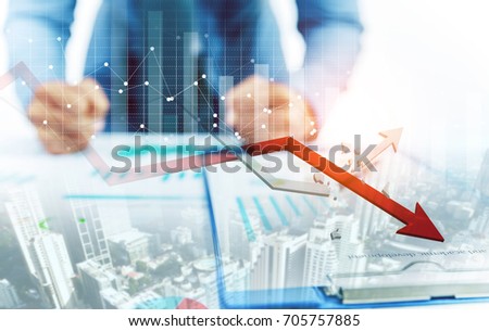 Businessman point at decreasing graph and increasing broken graph with city background Royalty-Free Stock Photo #705757885