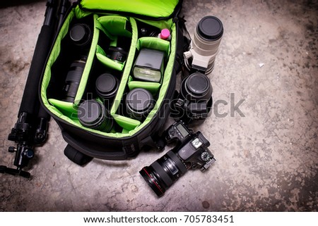 Photographer pack his camera and lenses to bagpack. Bag appliances for photography top view. Royalty-Free Stock Photo #705783451