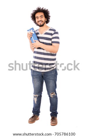 Full length shot of handsome happy beard young man smiling and holding a blue gift box, guy wearing striped t-shirt and jeans, isolated on white background