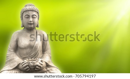 buddha statue isolated on blurred abstract green springtime background in sunshine