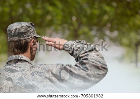 Digital composite of Soldier man raising arm against green background