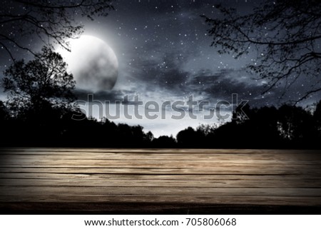 wooden table with dark sky and moon in halloween